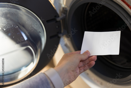 Woman putting a laudry sheet in the washing machine