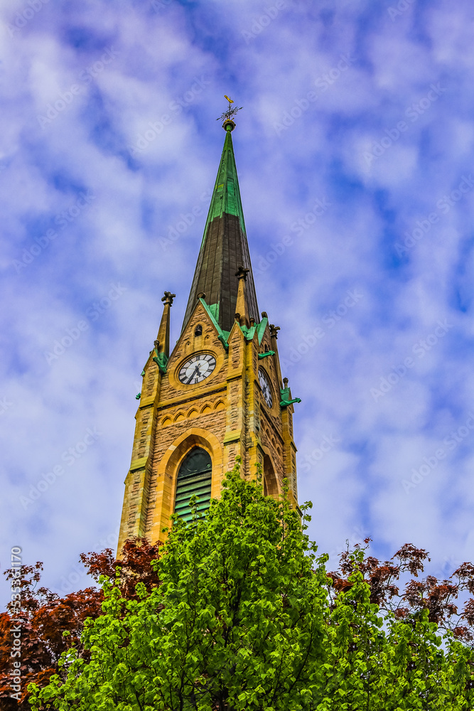 Fototapeta premium A view of Oscar´s Church´s tower in Stockholm (Oscarskyrkan) surrounded by trees