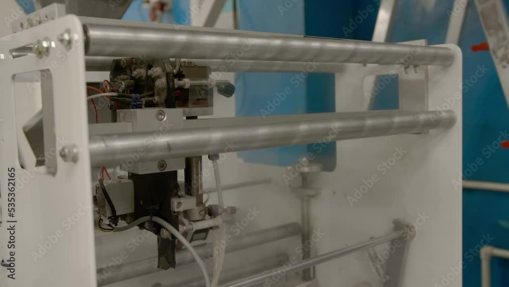 packaging machine in production. a roll with a transparent film packs the finished product. packaging machine in production. a roll with a transparent film packs the finished product.