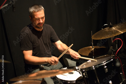 Drummer in rock band recording music in the professional recording studio