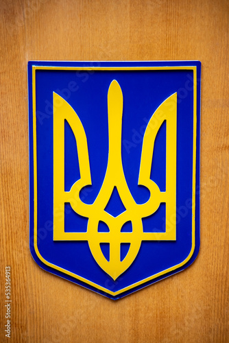bright coat of arms of ukraine on a wooden background photo
