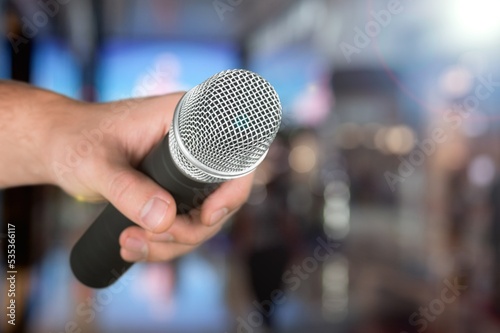 Classic black microphone with stage lighting background