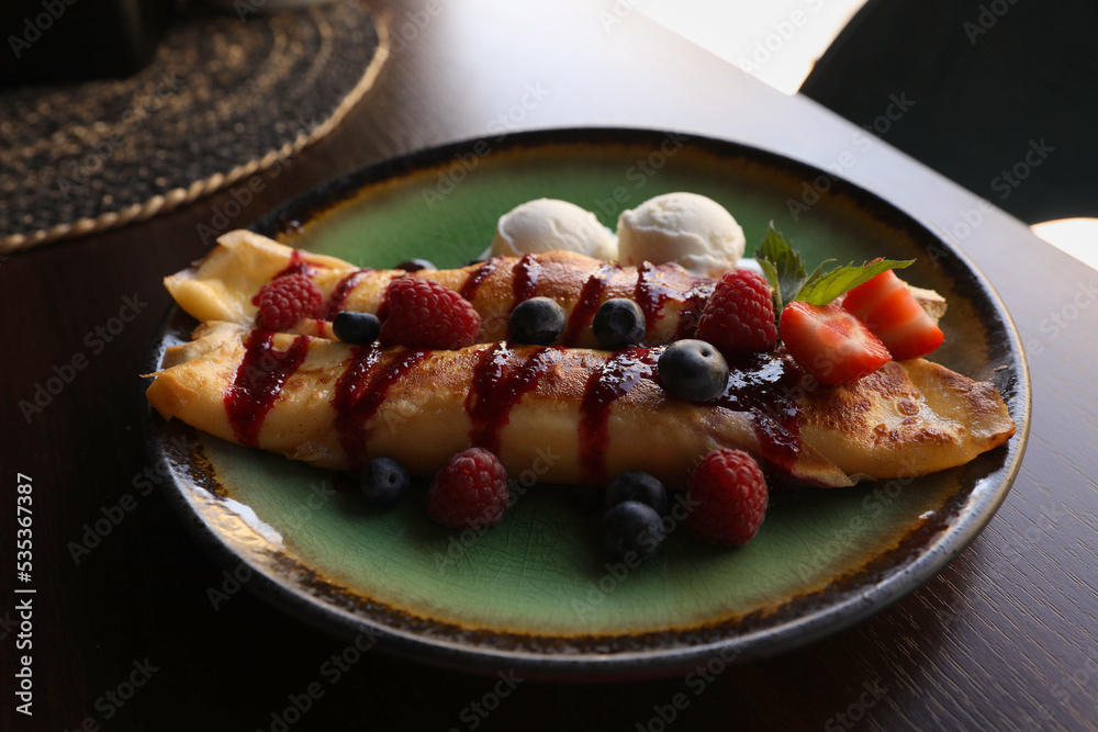 Delicious pancakes with fresh berries and ice cream on wooden table, closeup Delicious pancakes with fresh berries and ice cream on wooden table, closeup