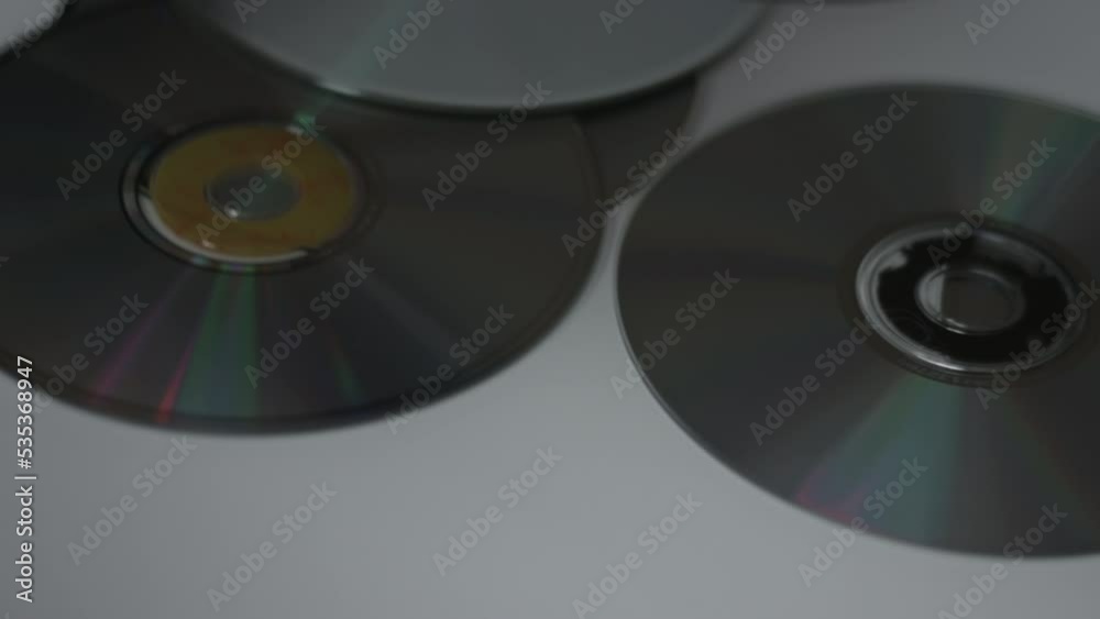 CDs Shine & Reflect On Slowly Rotating White Background CDs Shine & Reflect On Slowly Rotating White Background