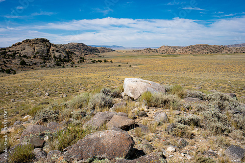 Landscape view of Granite Mountains of Wyoming with sagebrush and grass covered prairie and cirrus white clouds photo