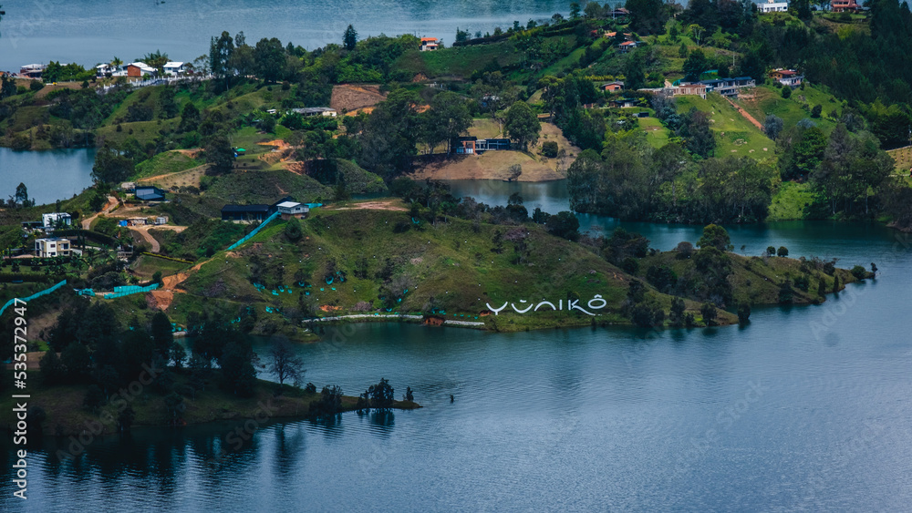 Aerial Drone Top Notch Flying Above Guatape Roads Village Lake and Islands Day Light near Medellin Colombia Misty Morning light over Houses