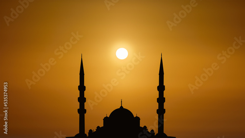 silhouette islamic mosque with dome and two tower with background of sunrising