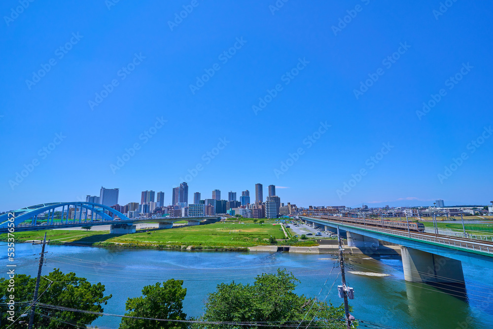 東京都大田区の多摩川から川崎市中原区の高層マンション群と丸子橋を見る