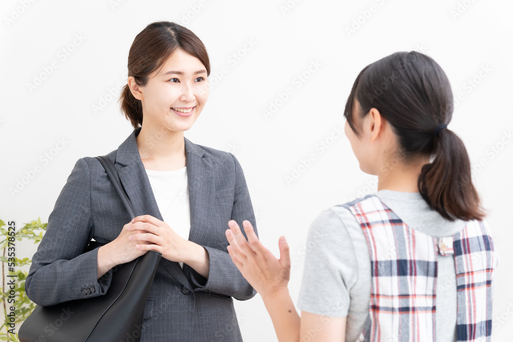 保育士と保育園に子供を送迎する保護者 保育士と保育園に子供を送迎する保護者