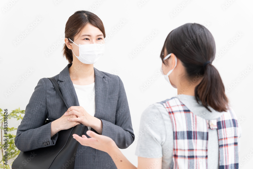 マスクをつけて会話をする保育士と保護者