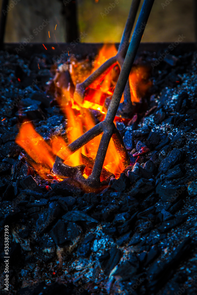 a cattlemarking iron being heated over the coals Stock Photo Adobe Stock