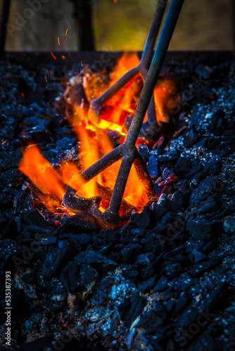a cattle-marking iron being heated over the coals