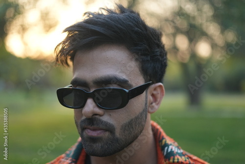 young man wearing jacket walking in park
