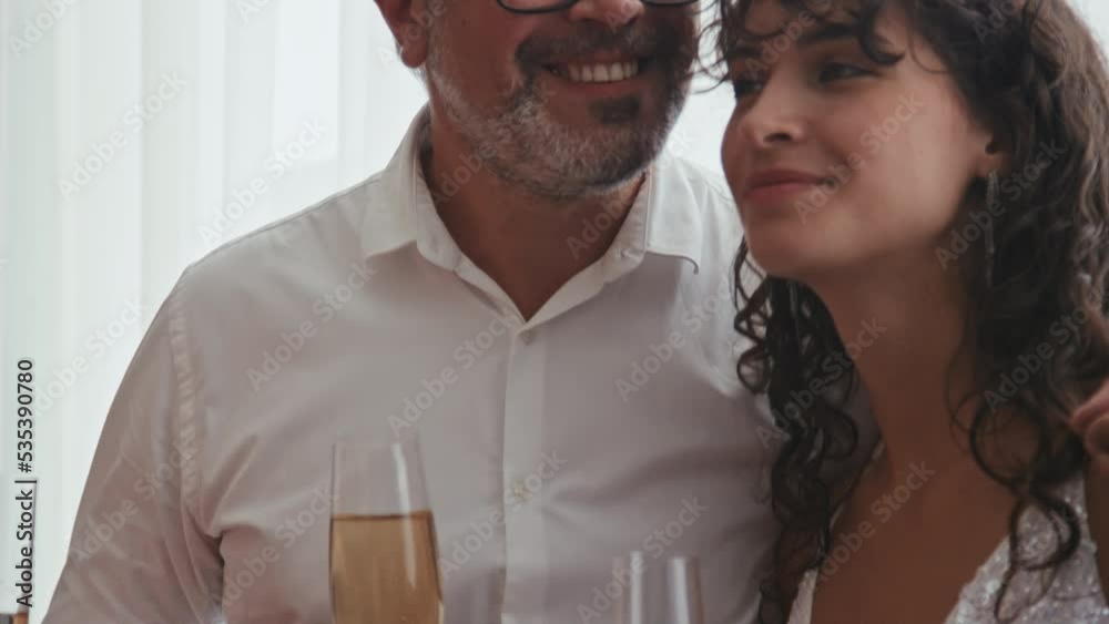 Medium close-up of happy parents and friends celebrating wedding day of young woman, proud father hugging his daughter