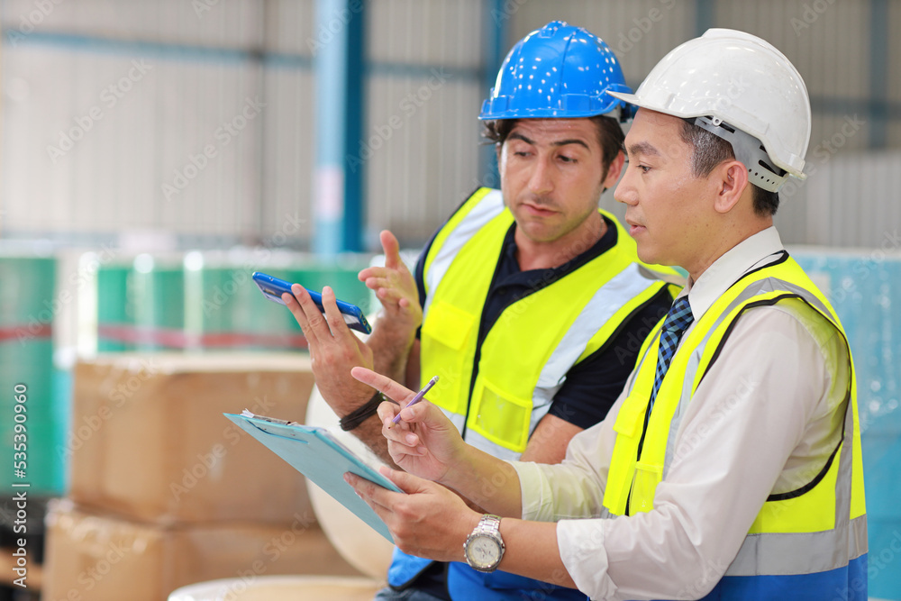 Fototapeta premium Group of technician engineer and businessman in protective uniform standing and discussing, researching, brainstorming and planning work together with tablet at industry manufacturing factory