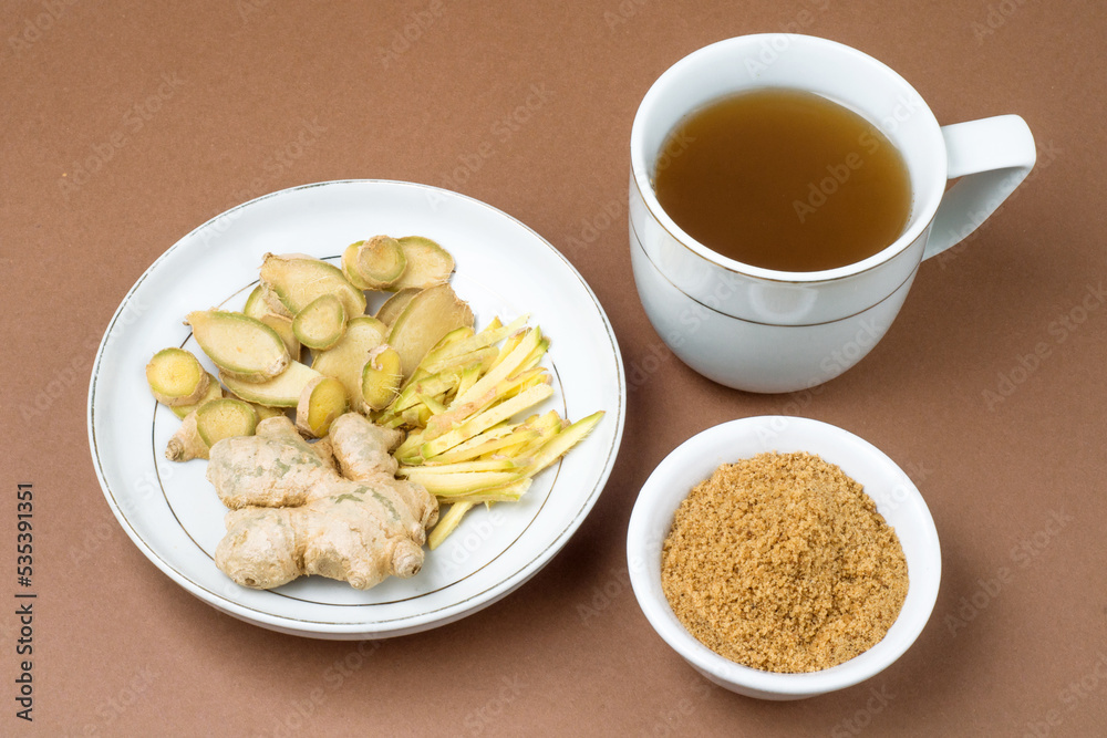 hot ginger. sliced ginger and powder on brown background hot ginger. sliced ginger and powder on brown background