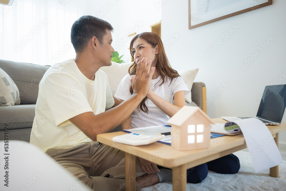 Asian couple in home or house. To compare prices, interest, credit. Include laptop, calculator and document on table. Concept for marriage, loan, finance, insurance, mortgage, real estate and property Asian couple in home or house. To compare prices, interest, credit. Include laptop, calculator and document on table. Concept for marriage, loan, finance, insurance, mortgage, real estate and property