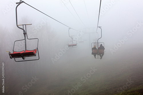 Mountain lift takes tourists to the mountain in dense fog