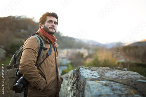 Man outdoors in nature during fall season. Adult male hiker photographer standing looking at camera. Copy space.