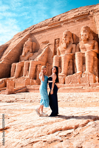Two women posing near Abu Simbel Egyptian temple in Egypt photo