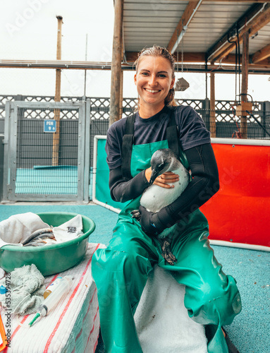 Wallpaper Mural Woman in green overall holding a penguin Torontodigital.ca