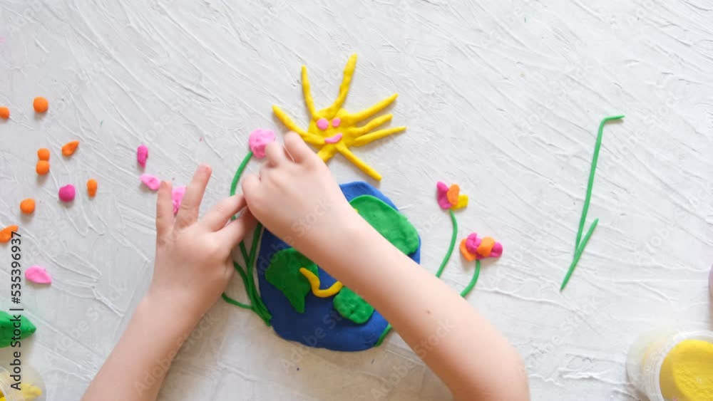 Child sculpturing plasticine planet for earth day. Protection of environment, Save our planet. Ecology concept. Concept of art learning and education, love earth , save world and unity.