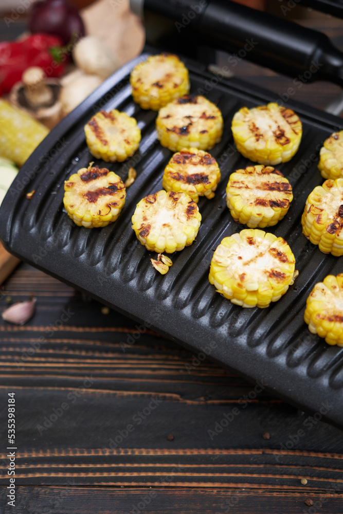 cooking at home on electric grill - sliced corn cobs cooking at home on electric grill - sliced corn cobs