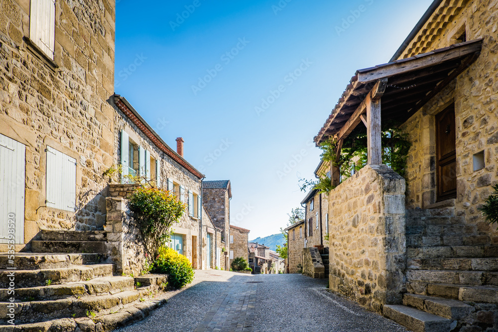 street of Boucieu Le Roi, with beautiful stone medieval stone houses with colorful shutters in Ardeche (France)