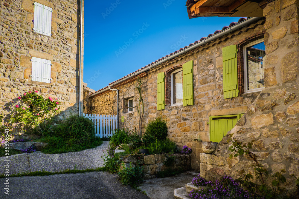 street of Boucieu Le Roi, with beautiful stone medieval stone houses with colorful shutters in Ardeche (France)