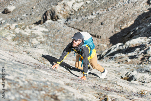 Man climbs up rock in mountain