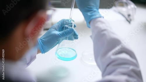 young chinese doctor doing  chemical experiment in library photo