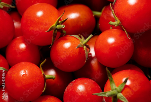 Red cherry tomatoes as background. © schankz