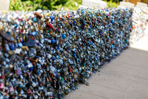 Old and new padlocks with names and dates written on them lock on a bridge as a sign of love in San Antonio, Texas.