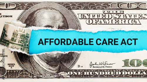 Words Affordable Care Act ACA written on with American Dollar-bills. The word Affordable Care Act on dollar usa background. The Patient Protection and Affordable Care Act