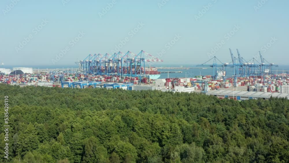 Aerial view of a large commercial port with a container ship and containers and trucks. Gdansk. Poland. international container port drone cinematic shot. Aerial view of a large commercial port with a container ship and containers and trucks. Gdansk. Poland. international container port drone cinematic shot.