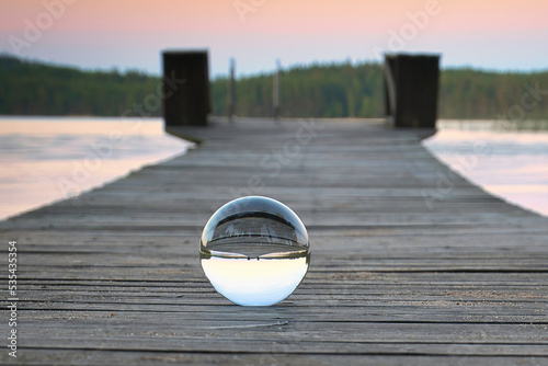 Glass ball on a wooden walkway on a Swedish lake at the blue hour. Nature Scandinavia