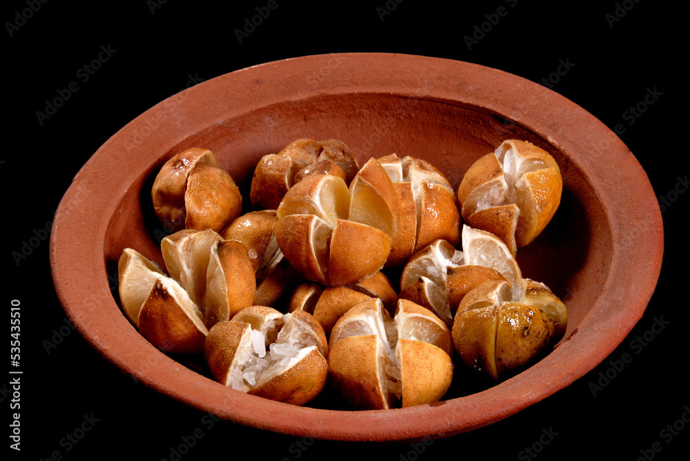 lime pickles in a clay pot, lime preserving process with salt, closeup, Sri Lankan home made lime pickle, isolated on black (Lunu Dehi) lime pickles in a clay pot, lime preserving process with salt, closeup, Sri Lankan home made lime pickle, isolated on black (Lunu Dehi)