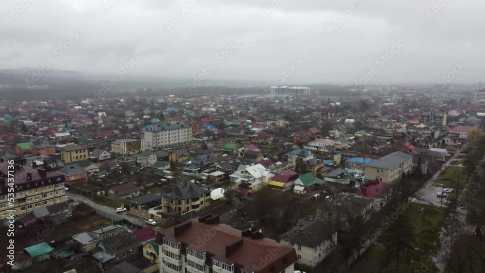Goryachy Klyuch, Russia - February 26, 2022: Shooting from a quadrocopter in the central part of the city. Foothills of the Caucasus. A cloudy winter day in a southern city. Goryachy Klyuch, Russia - February 26, 2022: Shooting from a quadrocopter in the central part of the city. Foothills of the Caucasus. A cloudy winter day in a southern city.
