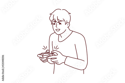 Guy with joystick playing computer games at home. Young man with joypad have fun engaged in videogame. Addiction and hobby. Vector illustration. 