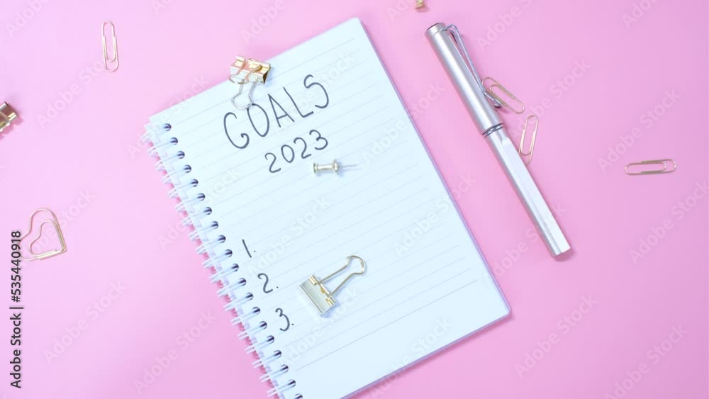 The inscription goals 2023 on notepad on pink background, top view. The inscription goals 2023 on notepad on pink background, top view.