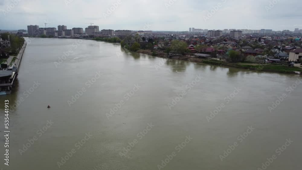 KRASNODAR, RUSSIA - APRIL 24, 2021: The Kuban River and residential buildings on the other side of the river. 4K. KRASNODAR, RUSSIA - APRIL 24, 2021: The Kuban River and residential buildings on the other side of the river. 4K.