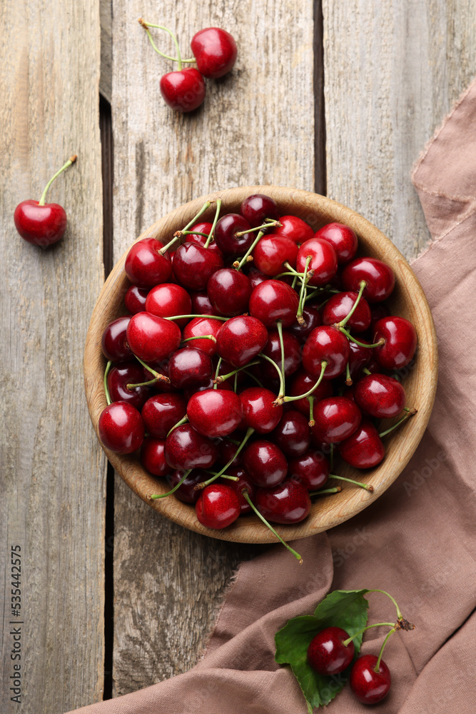 Fresh ripe cherries and towel on wooden table, flat lay Fresh ripe cherries and towel on wooden table, flat lay