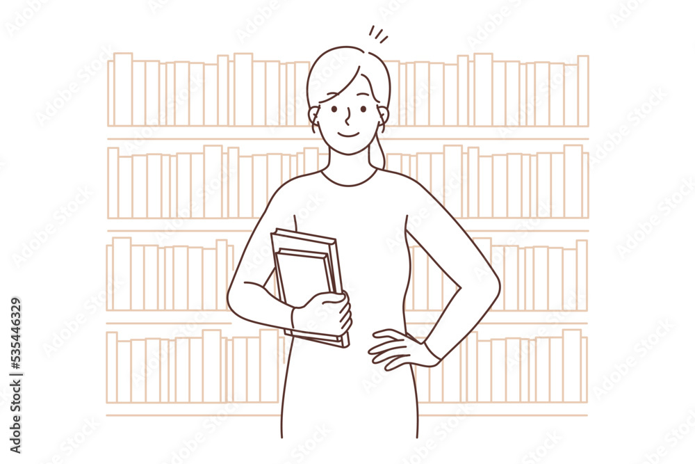 Smiling woman holding books standing in library Smiling woman holding books standing in library