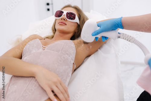 Fotografía Beautician doing epilation on female's armpit in beauty center