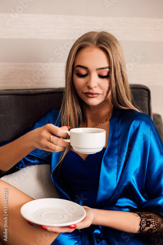 Beautiful sexy girl drinking coffee in the morning in a bathrobe in the hotel