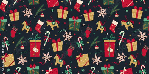 Vector seamless pattern with Christmas decoration in flat style. New Year stylish background of Christmas gift boxes, presents, socks, toys, candy cane, snowflake, fur tree branch, stars and confetti.