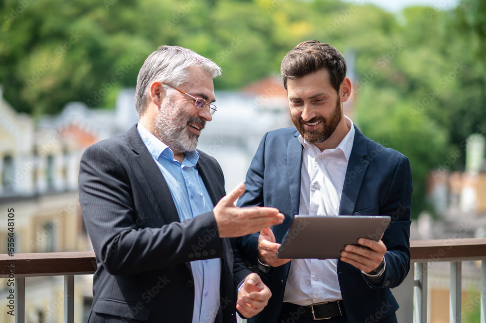 Two businessmen discussing the project details and looking involved Two businessmen discussing the project details and looking involved
