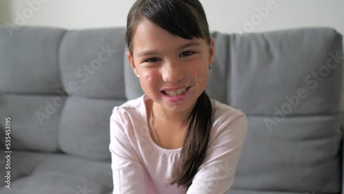 Close up portrait of caucasian little brunette girl in pink shirt smiling look at camera. Adorable kid smile. Happy childhood concept 