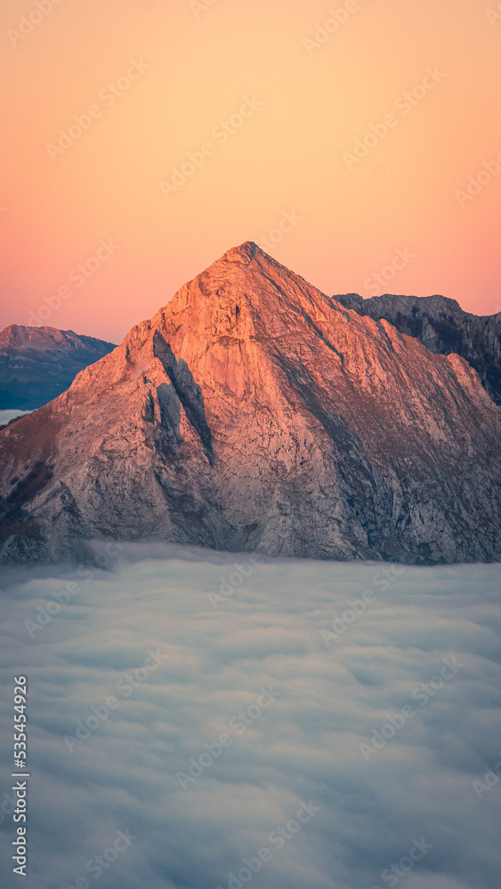 Fototapeta premium Amanecer en la montaña sobre la niebla