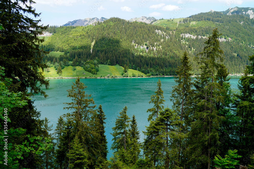 scenic emerald-green alpine lake Haldensee surrounded by lush green trees in the Alps of the Tannheim valley or Tannheimer Tal, Tirol, Austria